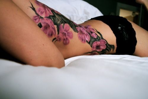 点击大图看下一张：女性腰部绚丽的花朵纹身