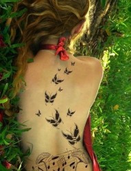 女性背部音符和花朵纹身