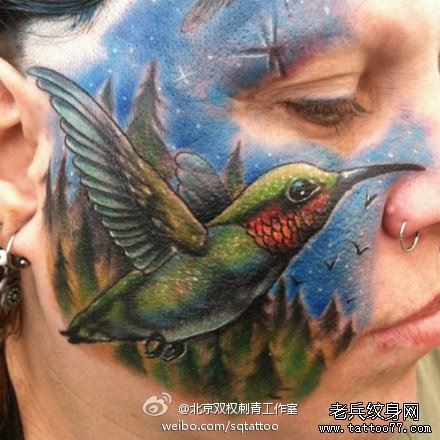 点击大图看下一张：一幅另类的欧美女性脸部蜂鸟纹身图片