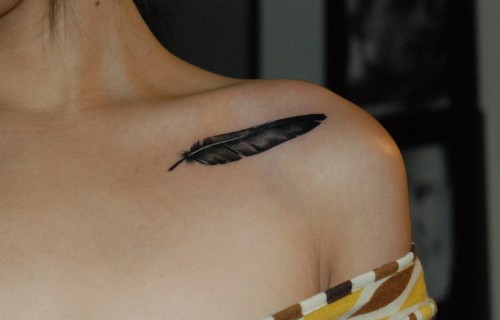 点击大图看下一张：女孩锁骨下羽毛纹身图