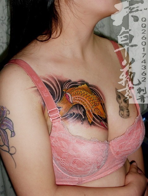 点击大图看下一张：女性胸部上的猫和鱼刺青纹身图案