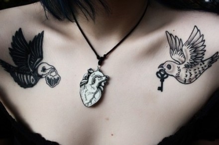点击大图看下一张：女性胸前两只燕子刺青