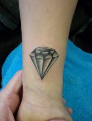 手腕上一颗淡色的钻石纹身