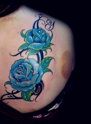 点击大图看下一张：女士后背蓝色玫瑰纹身图案