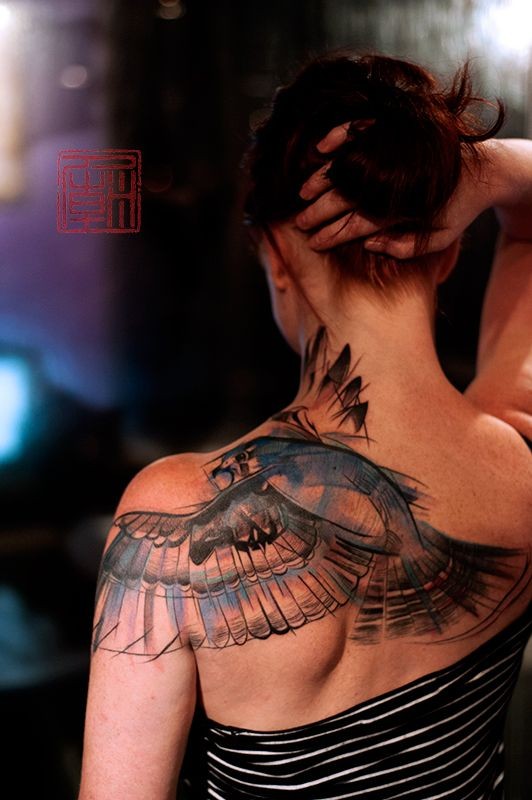 点击大图看下一张：女性背部一只飞翔的大鸟纹身图案