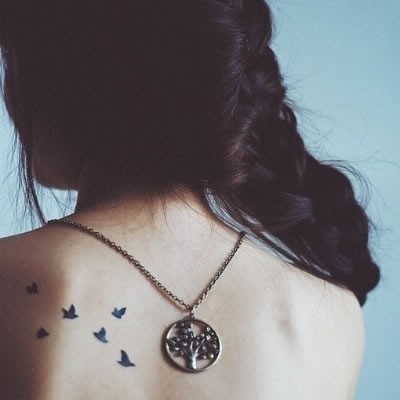 点击大图看下一张：女性背部一群小鸟刺青