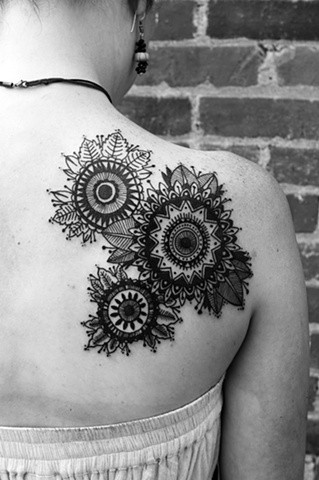 点击大图看下一张：女性背部漂亮的向日葵纹身