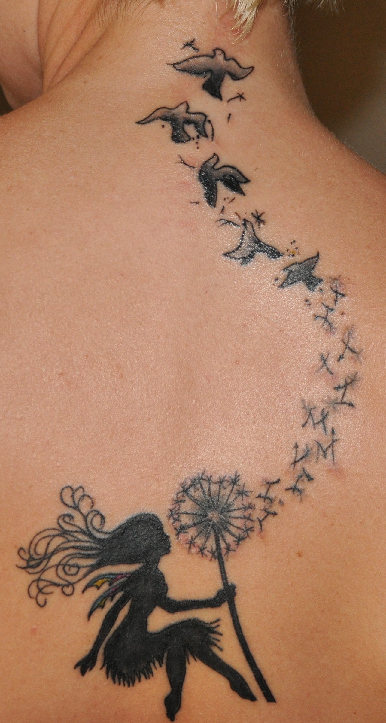 点击大图看下一张：背部漂亮的蒲公英小鸟纹身