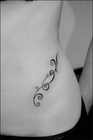 点击大图看下一张：女性腰部简单的花纹刺青