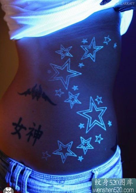点击大图看下一张：女性腰部的荧光星星图案纹身
