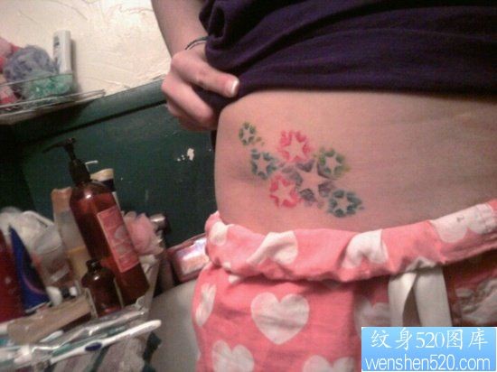 点击大图看下一张：女人腹部小巧潮流的五角星纹身图片
