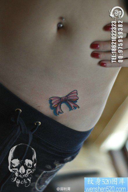 点击大图看下一张：女人腹部时尚小巧的蝴蝶结纹身图片