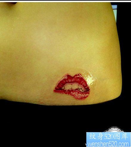 点击大图看下一张：女人腹部一幅精美的红唇纹身图片