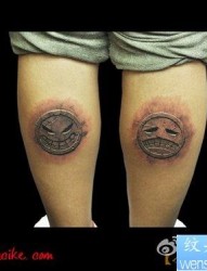 腿部超酷的石雕笑脸与哭脸纹身图片