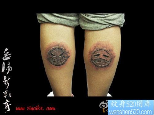 点击大图看下一张：腿部超酷的石雕笑脸与哭脸纹身图片