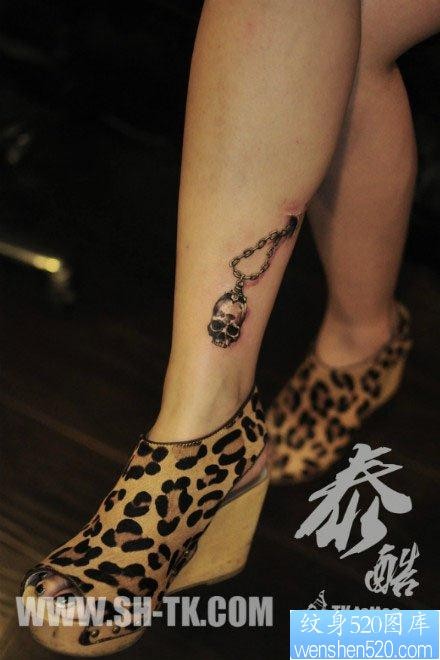 点击大图看下一张：女人腿部潮流精美的骷髅吊链纹身图片
