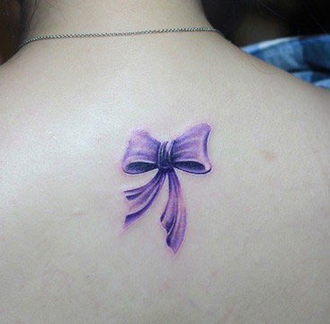 点击大图看下一张：背部紫色蝴蝶结纹身