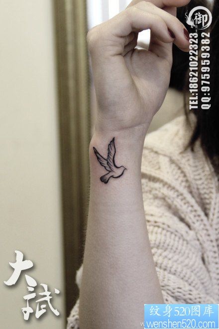 点击大图看下一张：女人手腕处小巧的图腾鸽子纹身图片
