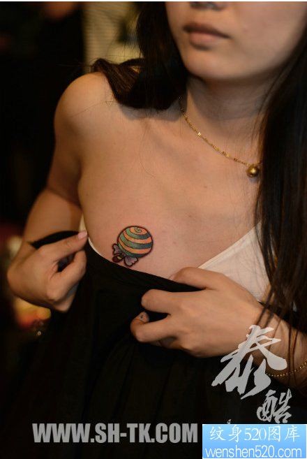 点击大图看下一张：女人胸前潮流小巧的棒棒糖纹身图片