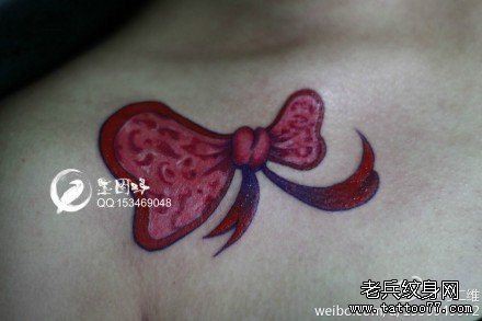 点击大图看下一张：女人锁骨小巧潮流的蝴蝶结纹身图片