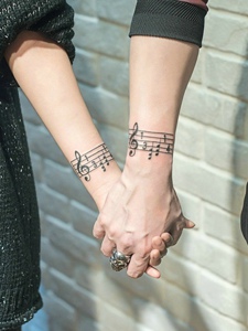 热爱音乐的情侣手臂音乐符纹身图片