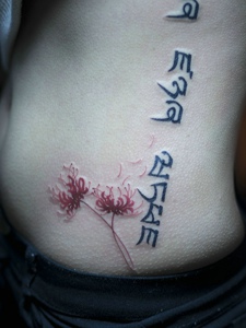彼岸花与梵文结合的侧腰部纹身图片