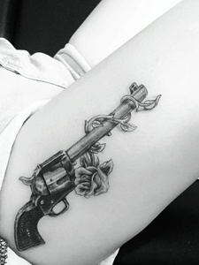 手臂上一把帅气精致的枪纹身图案