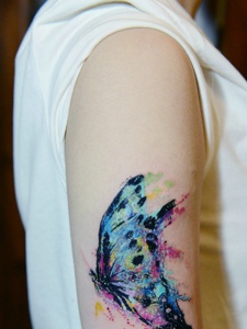翩翩起舞的花色蝴蝶手臂纹身图片