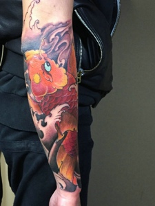 手臂精致完美的的红鲤鱼刺青