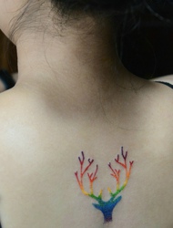 女生白皙的后背有着创意彩色树枝纹身