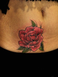 落在女生腹部一朵花朵纹身图片