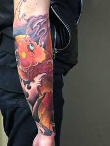 手臂靓丽精致的红鲤鱼刺青