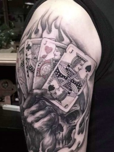 手握扑克牌的大臂个性纹身图案