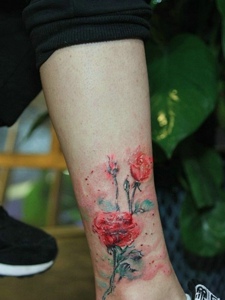 落在小腿部的水彩花朵纹身图片