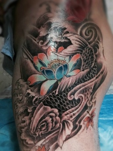 处在臀部的鲤鱼和莲花纹身图片