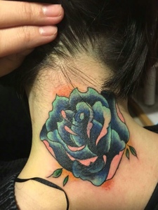 女生颈部上的一朵玫瑰花朵纹身