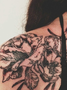 黑衣女士肩膀上的花朵纹身图片