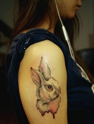 女生大臂上的小白兔纹身可爱极了