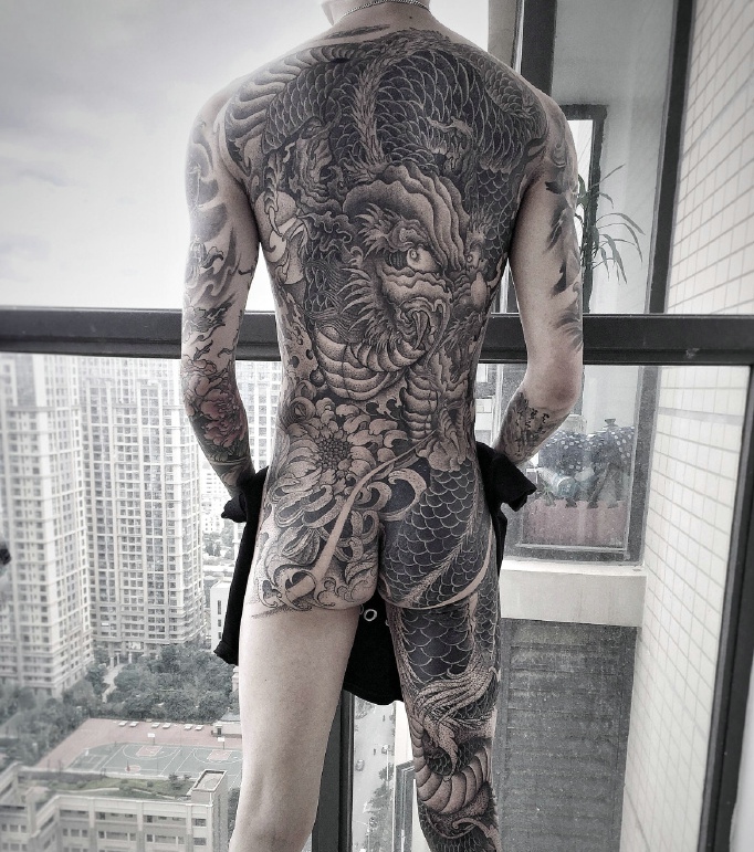 点击大图看下一张：站在高层商务楼白领男士满背个性邪龙纹身(2/2)