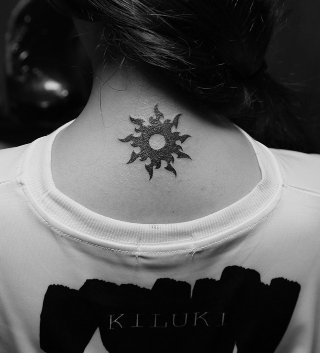 点击大图看下一张：女生后背上像似太阳图案的小巧纹身(1/1)