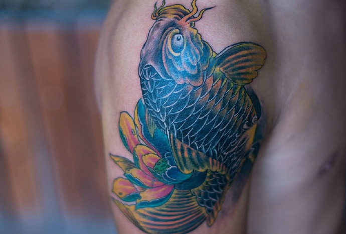 点击大图看下一张：大臂上的个性活跃彩色鲤鱼纹身(2/2)