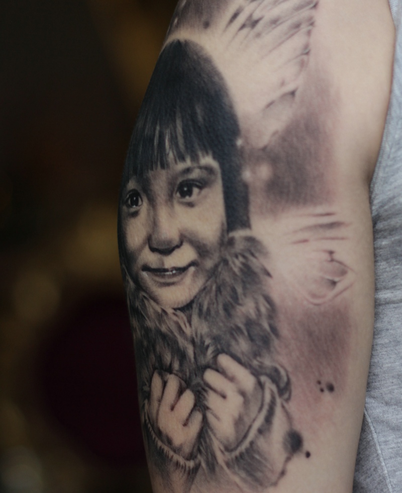 点击大图看下一张：慈祥的父亲大臂上有着爱女肖像纹身(2/3)