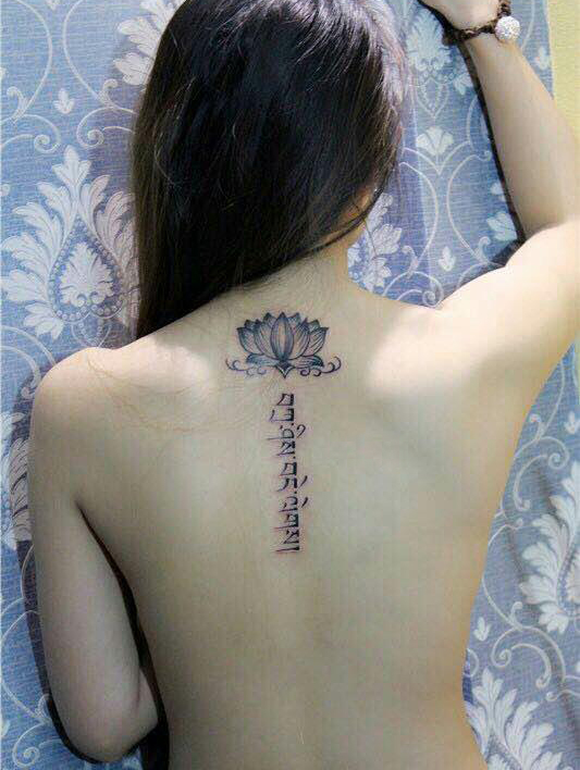 点击大图看下一张：女生脊椎部荷花和梵文结合的纹身(1/1)