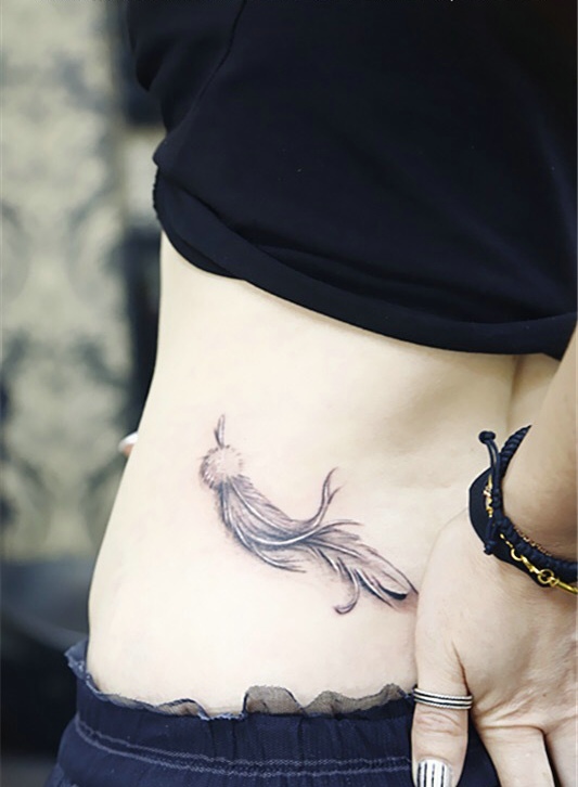 点击大图看下一张：飘在美女腰部上的羽毛纹身图片(1/1)