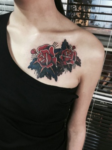 露肩女生锁骨下的两朵红玫瑰纹身图片
