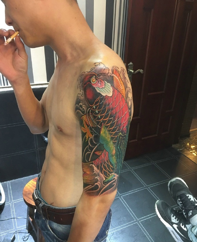 点击大图看下一张：酷男手臂红鲤鱼纹身图片更加帅气