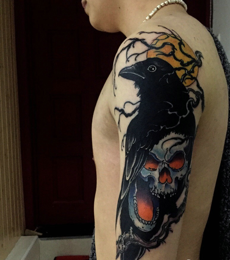 点击大图看下一张：大臂乌鸦与骷髅结合的纹身刺青