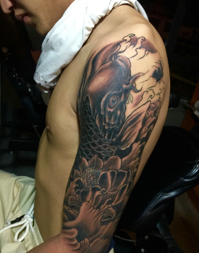 点击大图看下一张：莲花与鲤鱼结合的大臂纹身刺青