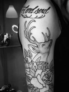 花丛中的小鹿与英文的花臂纹身图片