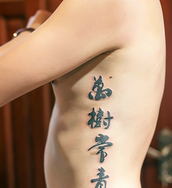 点击大图看下一张：侧腰部的汉字纹身图案显个性